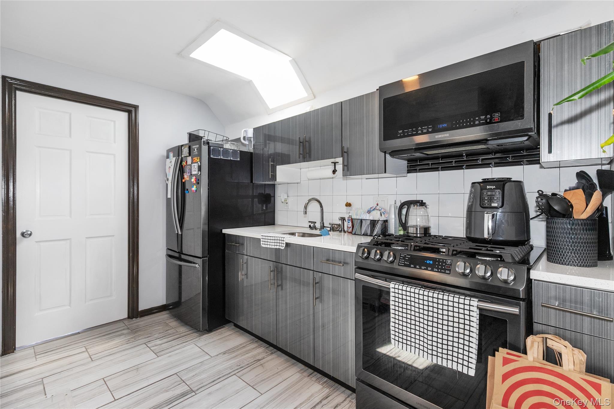 8713 135th Street, Unit 3 Queens, NY 11418 - Photo 13 of 22 a kitchen with stainless steel appliances granite countertop a refrigerator and a stove top oven