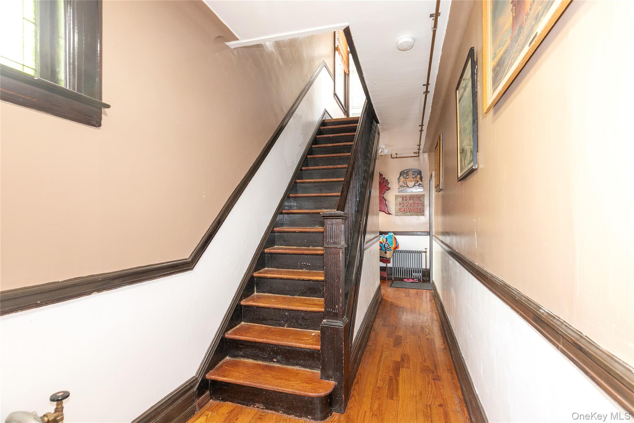 8713 135th Street, Unit 3 Queens, NY 11418 - Photo 7 of 22 a view of staircase with wooden floor and white walls