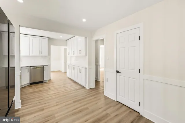 a view of a kitchen with white cabinets and wooden floor