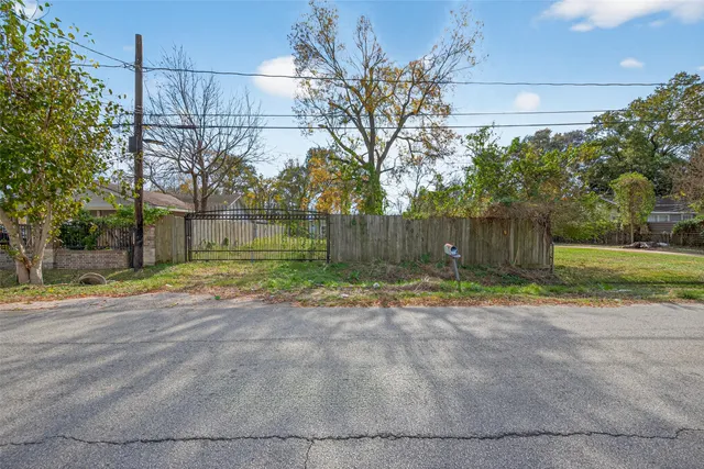 a view of a yard with wooden fence