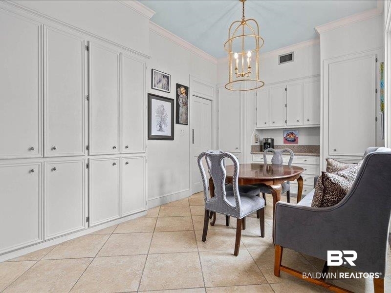109 Eaton Square Mobile, AL 36608 - Photo 10 of 26 Built-in cabinetry with panel detailing, stone-finish countertop, tile flooring, crown molding, and an ornate pendant light fixture