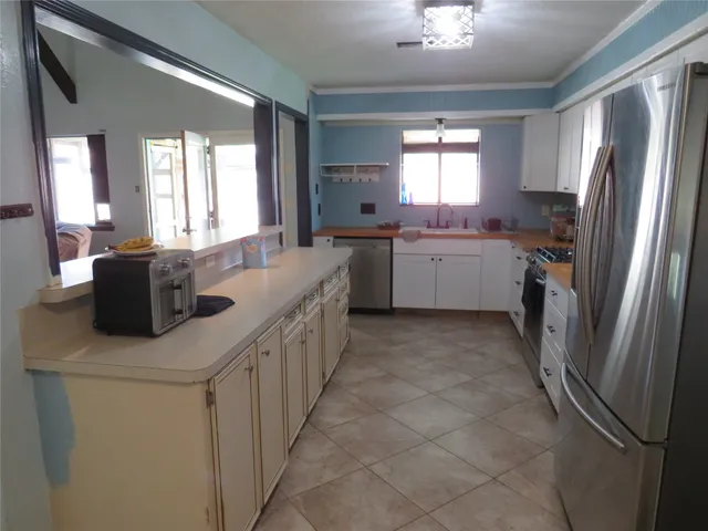 a kitchen that has a lot of cabinets in it and a refrigerator