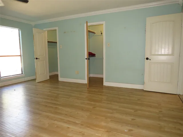 an empty room with wooden floor and closet