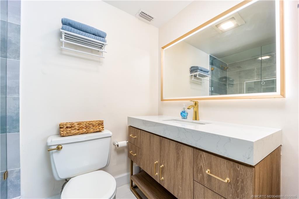 2355 Northeast Ocean Boulevard, Unit 19B Stuart, FL 34996 - Photo 16 of 20 a bathroom with a toilet a sink and mirror