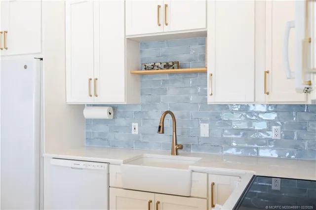 a kitchen with stainless steel appliances granite countertop a sink a stove and cabinets