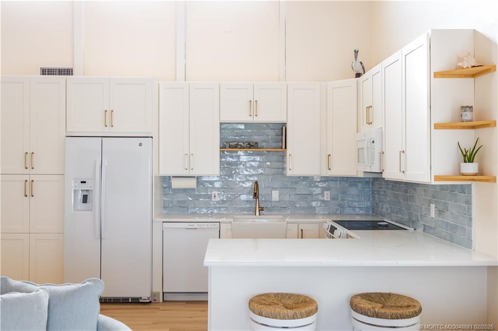 2355 Northeast Ocean Boulevard, Unit 19B Stuart, FL 34996 - Photo 5 of 20 a kitchen with kitchen island cabinets and refrigerator