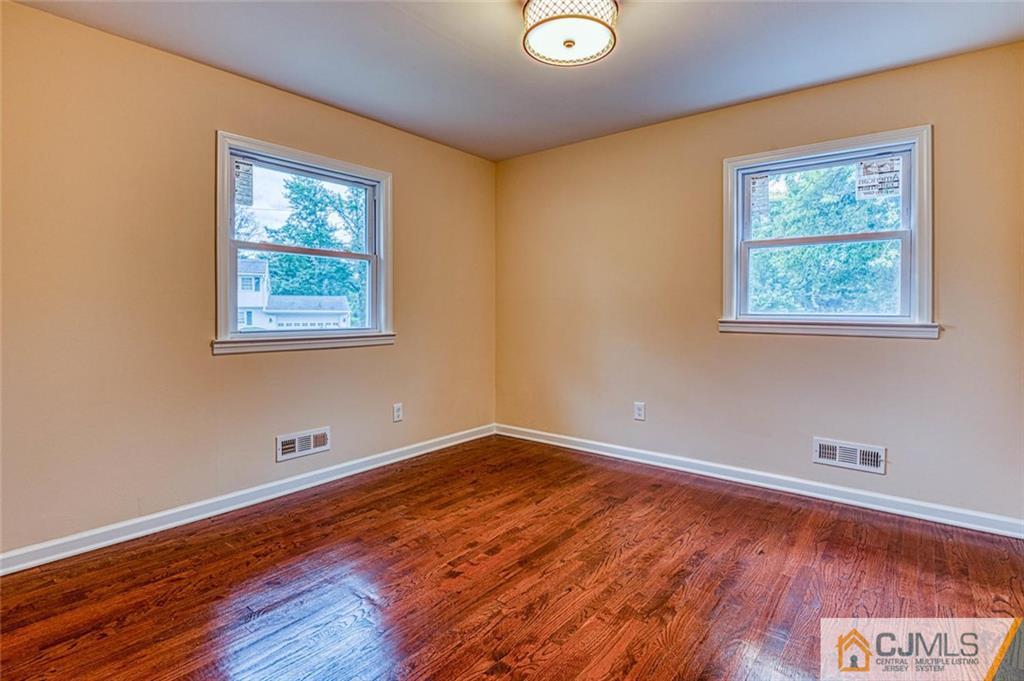 26 Colburn Road East Brunswick, NJ 08816 - Photo 16 of 22 an empty room with wooden floor and windows