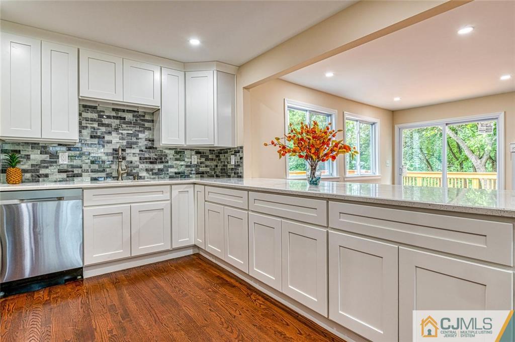 26 Colburn Road East Brunswick, NJ 08816 - Photo 6 of 22 a kitchen with white cabinets a sink and dishwasher with wooden floor