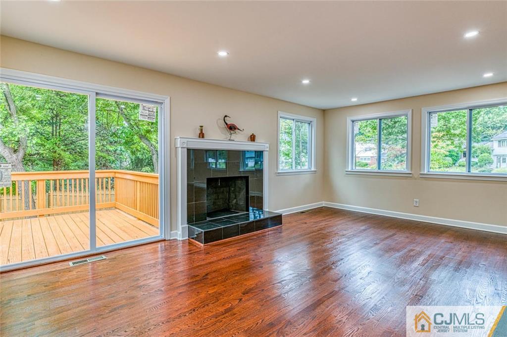 26 Colburn Road East Brunswick, NJ 08816 - Photo 10 of 22 an empty room with wooden floor fireplace and windows