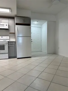 a kitchen with a refrigerator and a stove top oven