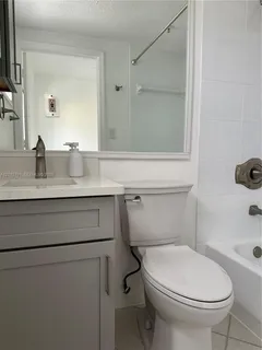 a bathroom with a granite countertop toilet sink and mirror
