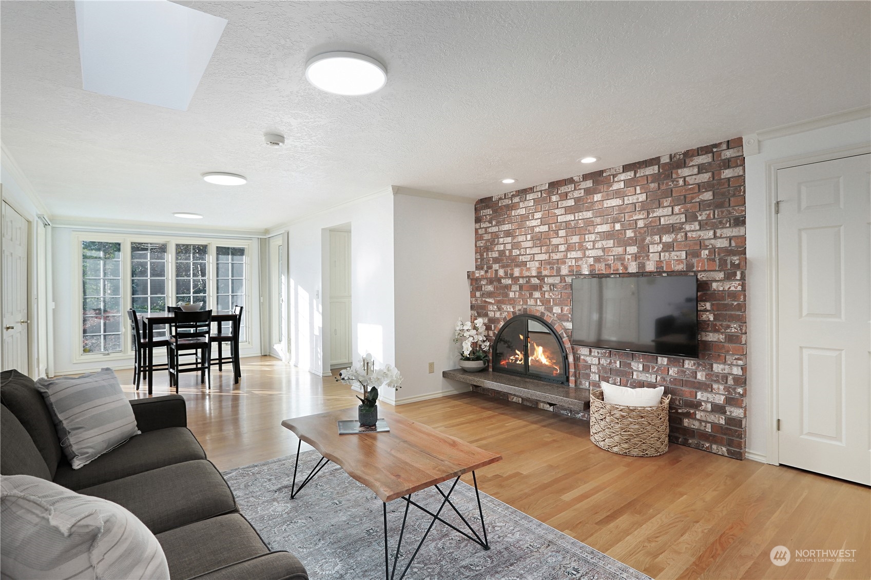 15203 Southeast 132nd Street Renton, WA 98059 - Photo 16 of 35 a living room with furniture a dining table and a fireplace
