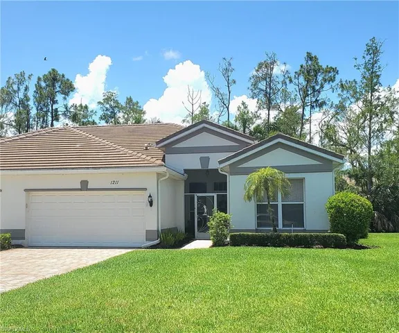 a front view of a house with a garden and plants
