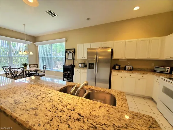 a kitchen with stainless steel appliances kitchen island granite countertop a refrigerator and a stove top oven