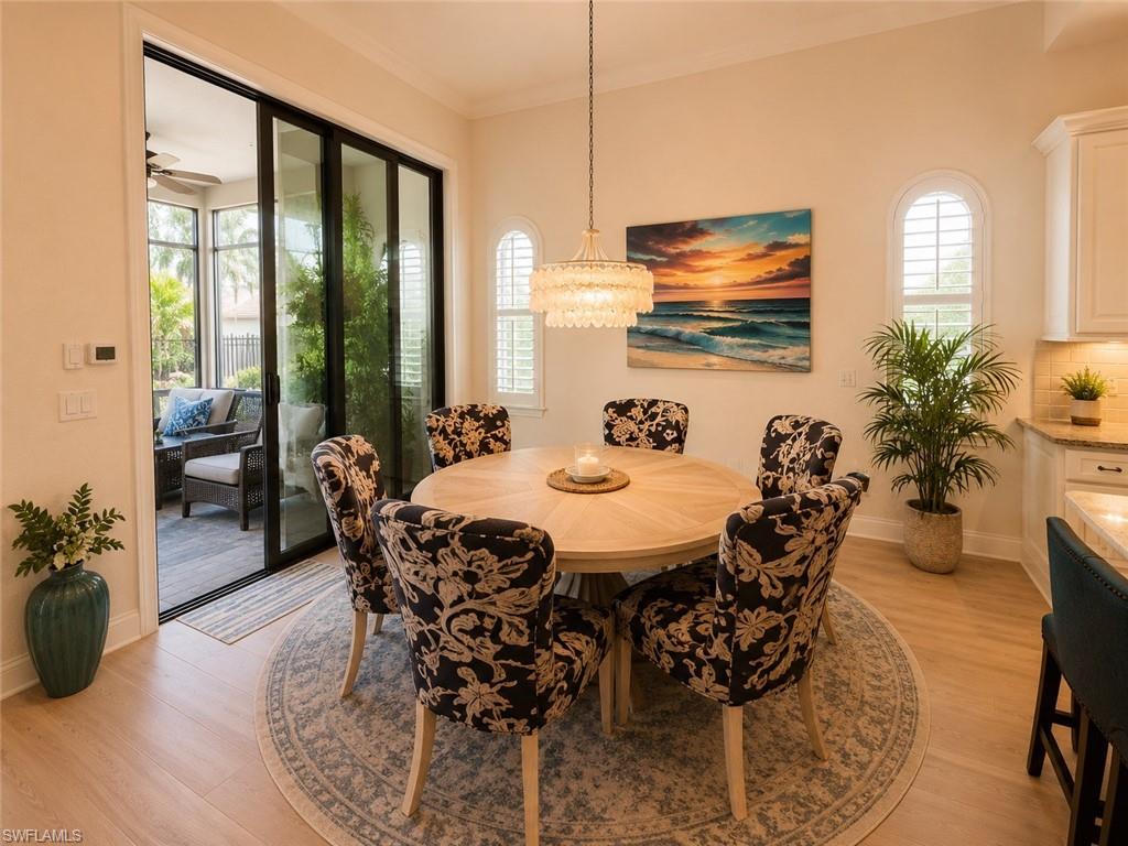 6574 Amarone Lane Naples, FL 34113 - Photo 6 of 44 a dining room with furniture window and wooden floor