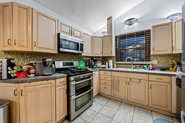 a kitchen with white cabinets stainless steel appliances and sink