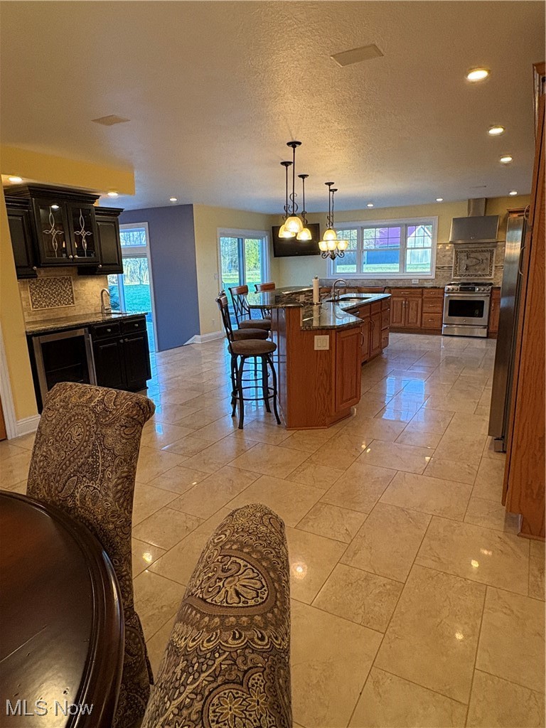 2504 Meloy Road Kent, OH 44240 - Photo 12 of 50 Kitchen with decorative backsplash, a kitchen breakfast bar, stove, refrigerator, and an island with sink