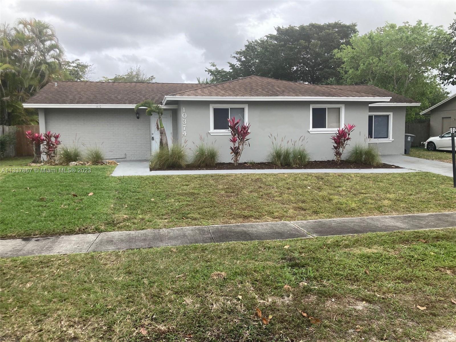 10374 Sleepy Brook Way Boca Raton, FL 33428 - Photo 1 of 12 a front view of a house with a yard