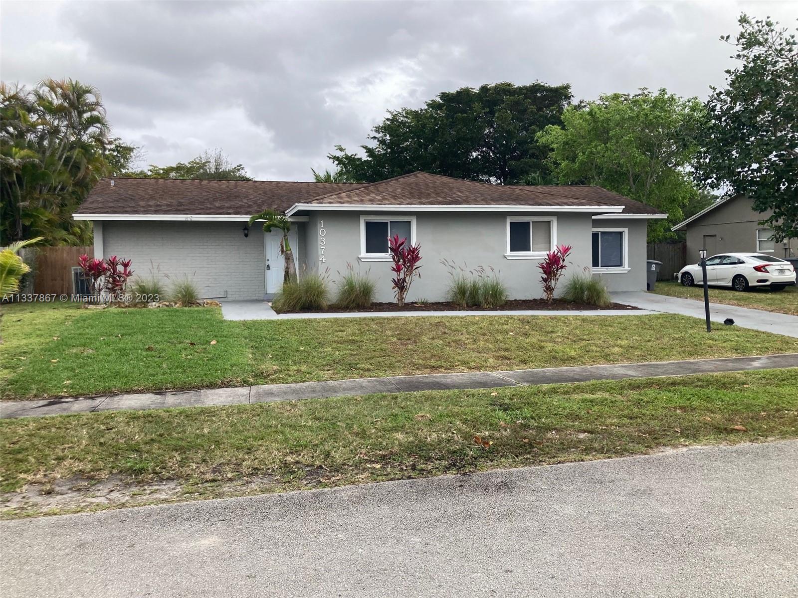 10374 Sleepy Brook Way Boca Raton, FL 33428 - Photo 2 of 12 a front view of a house with a yard and garage