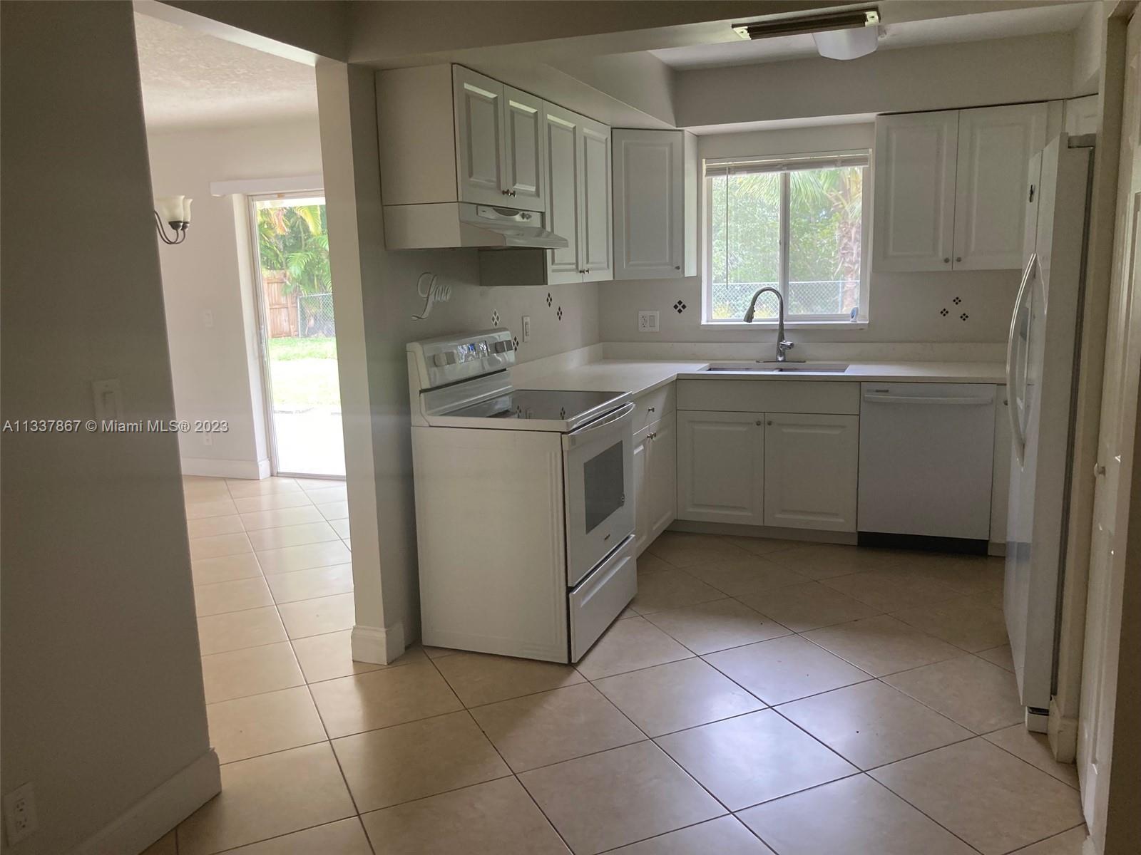 10374 Sleepy Brook Way Boca Raton, FL 33428 - Photo 4 of 12 a kitchen with a sink window and cabinets