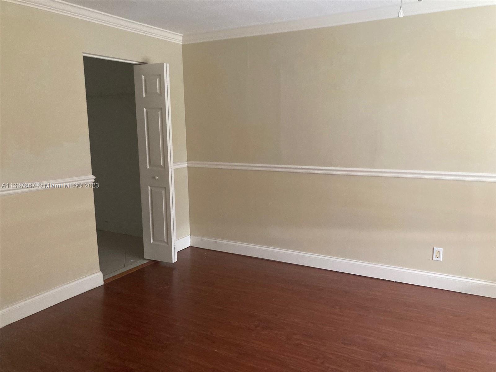 10374 Sleepy Brook Way Boca Raton, FL 33428 - Photo 6 of 12 an empty room with wooden floor and windows