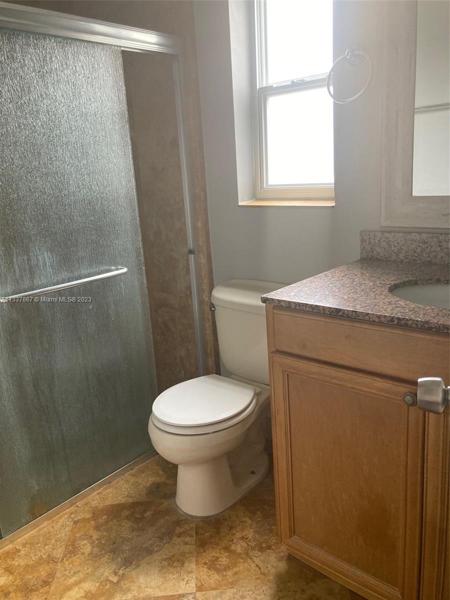 10374 Sleepy Brook Way Boca Raton, FL 33428 - Photo 10 of 12 a bathroom with a granite countertop toilet a sink and a shower