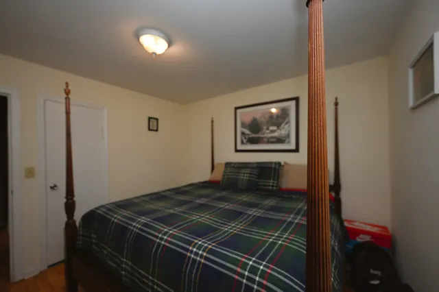 a bedroom with a bed and a painting on the wall