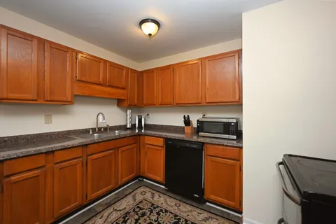 a kitchen with stainless steel appliances granite countertop a sink stove and cabinets