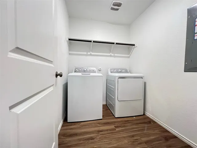 a large white kitchen with wooden floor