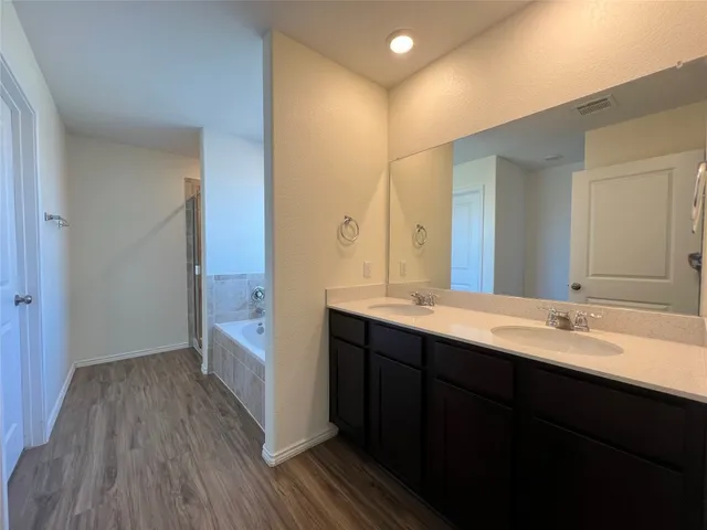 an empty room with windows and chandelier fan
