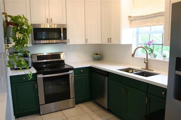 a kitchen with stainless steel appliances a stove sink and microwave