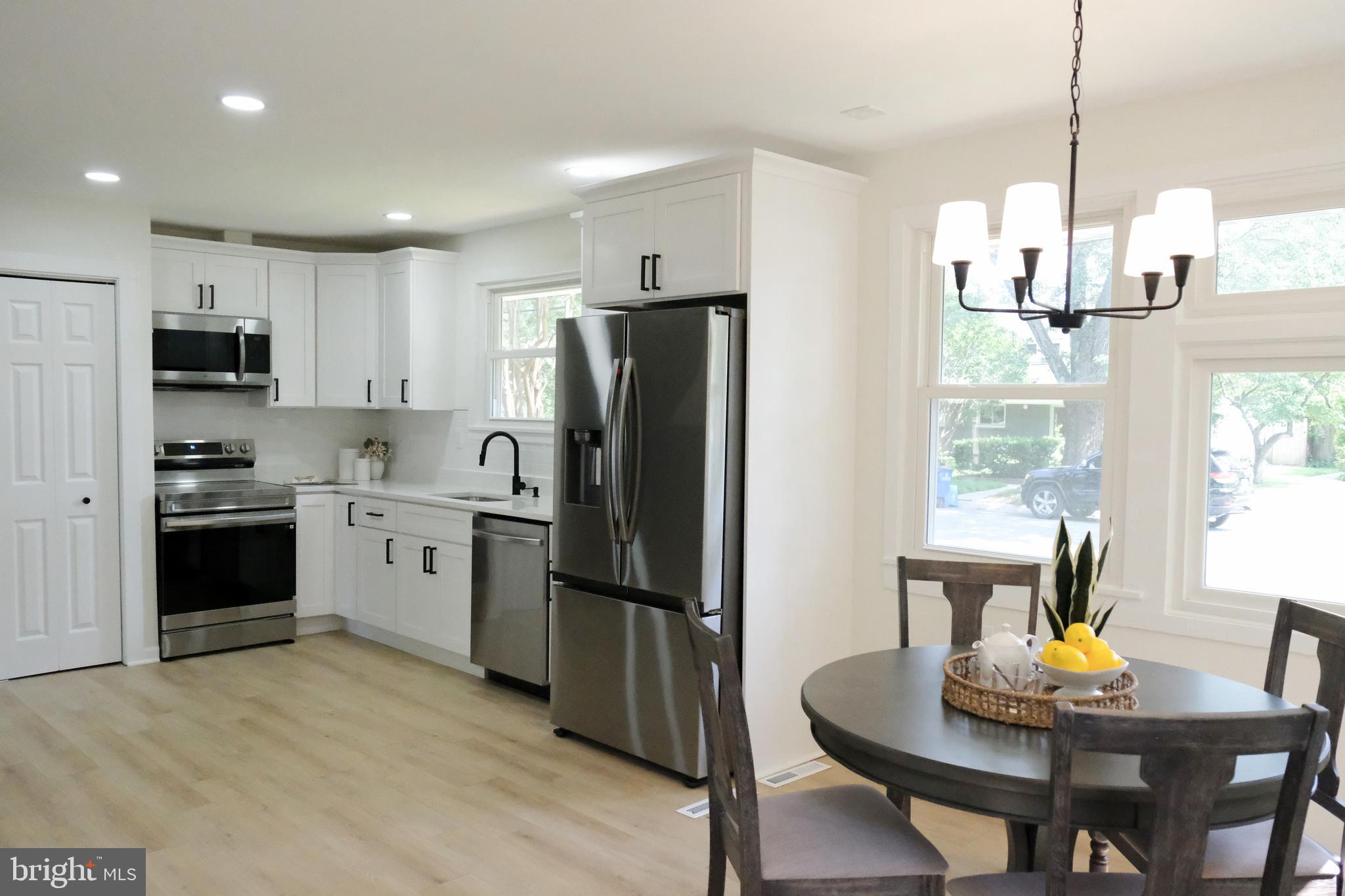 1825 Tilton Drive Silver Spring, MD 20902 - Photo 4 of 31 a kitchen with refrigerator a sink and chairs