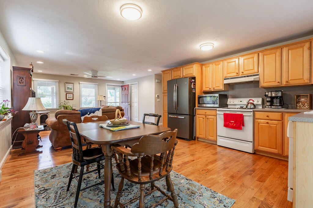 17 Valley Road Mashpee, MA 02649 - Photo 5 of 19 a kitchen with stainless steel appliances kitchen island granite countertop a table chairs and a refrigerator