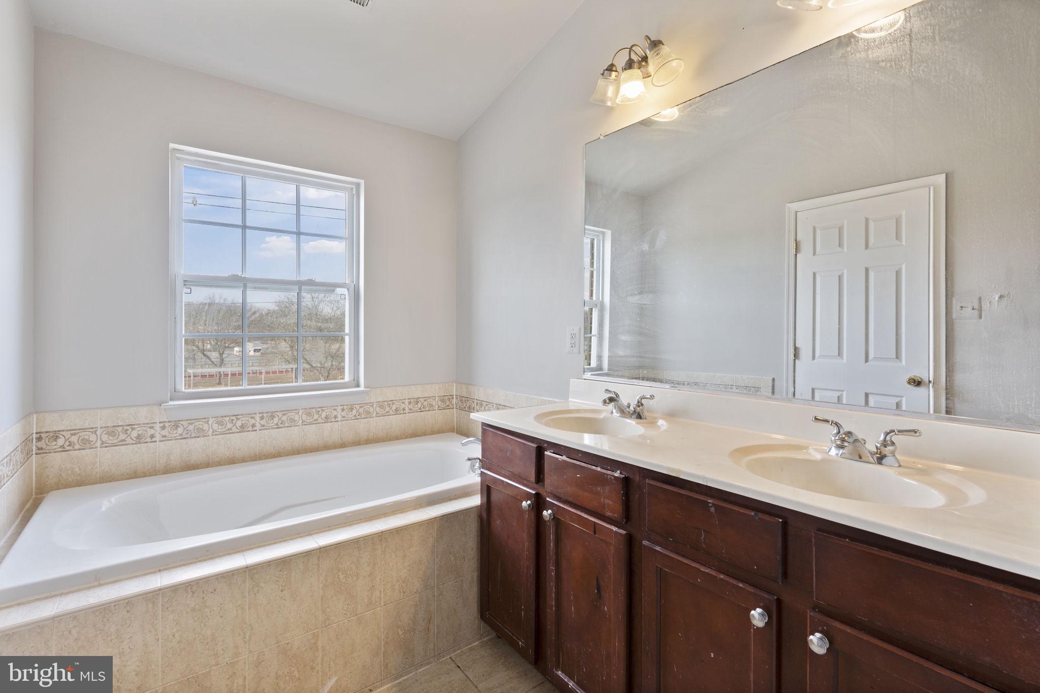 811 Middle River Road Baltimore, MD 21220 - Photo 26 of 55 a bathroom with a tub sink and mirror