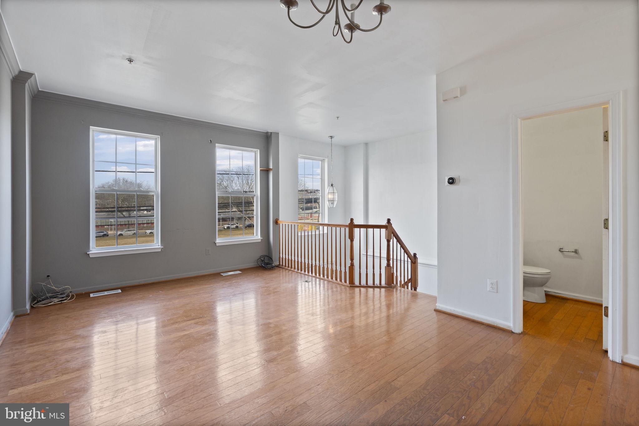 811 Middle River Road Baltimore, MD 21220 - Photo 8 of 55 an empty room with wooden floor and windows