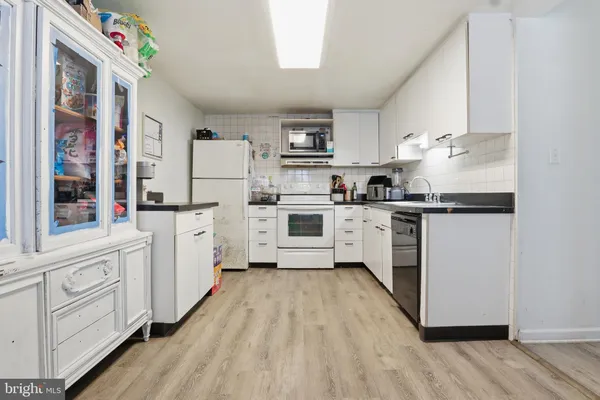 a kitchen with white cabinets and white appliances