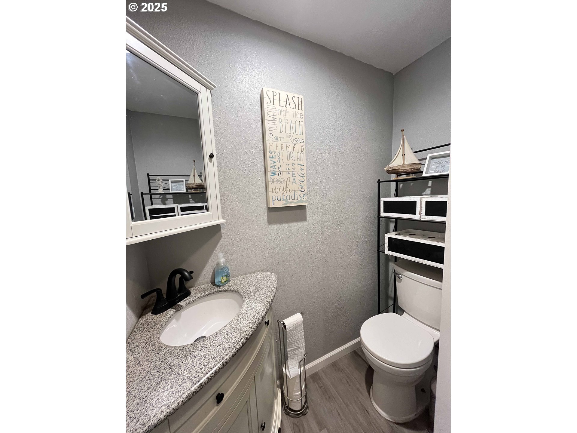 2045 19th Street Florence, OR 97439 - Photo 23 of 43 a bathroom with a granite countertop toilet sink and mirror