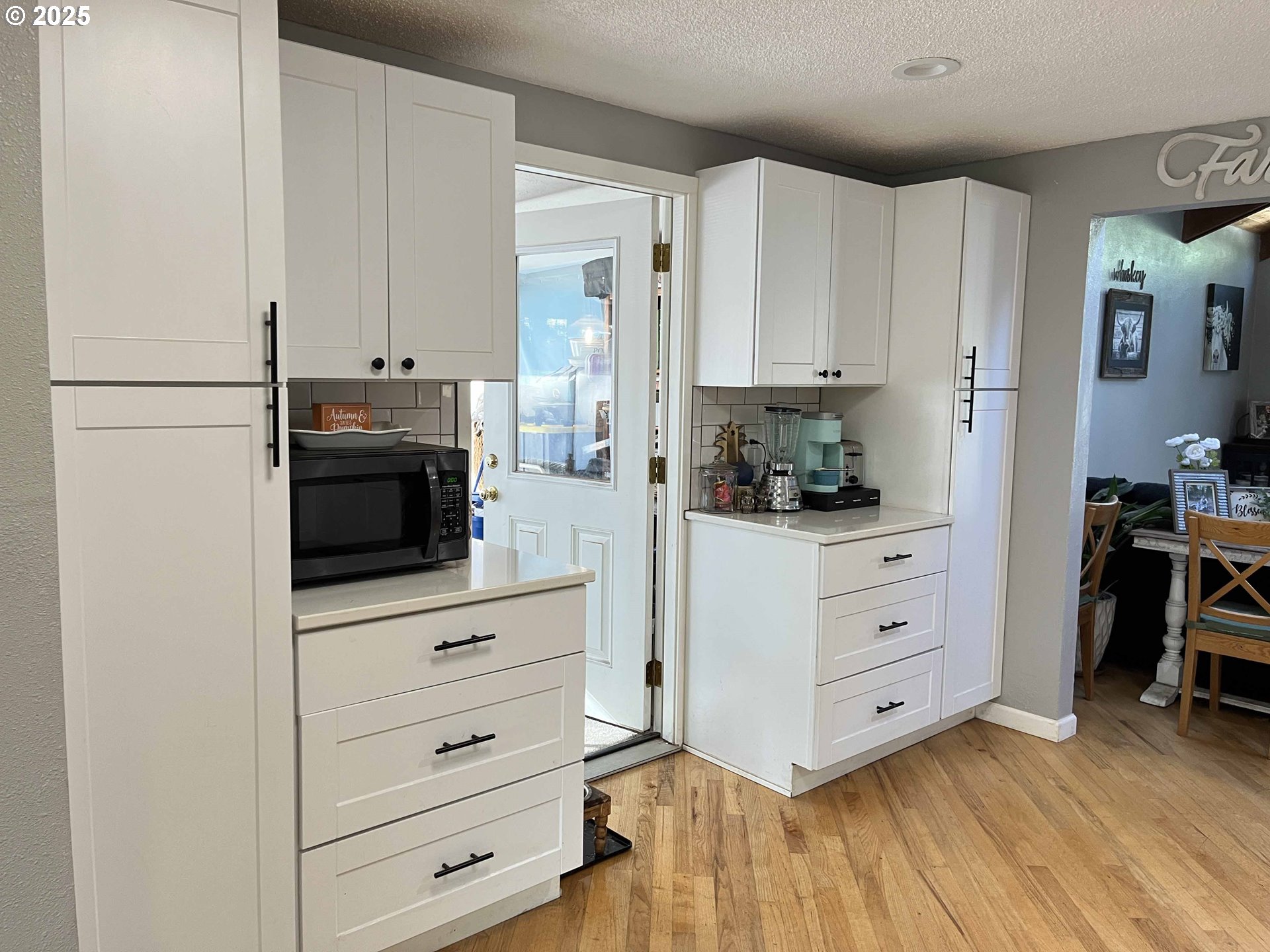2045 19th Street Florence, OR 97439 - Photo 26 of 43 a kitchen with white cabinets and stainless steel appliances