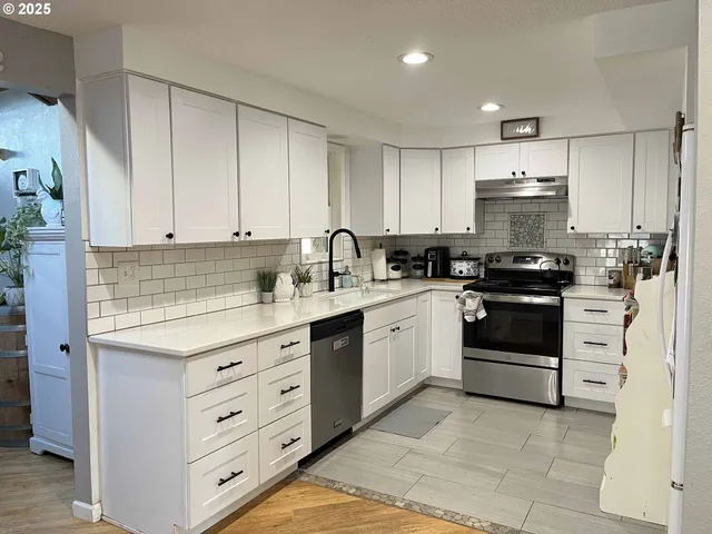 a kitchen with white cabinets and stainless steel appliances