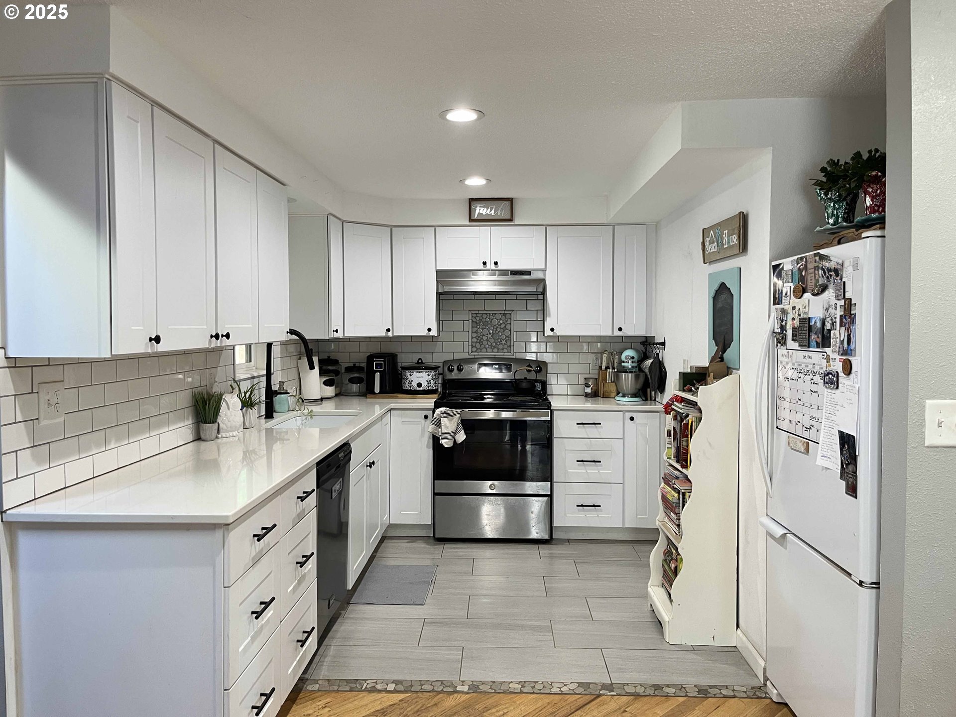2045 19th Street Florence, OR 97439 - Photo 28 of 43 a kitchen with white cabinets and stainless steel appliances