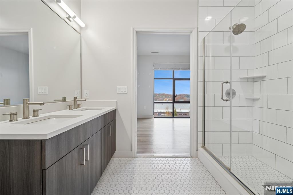 300 Market Street, Unit 422 Montvale, NJ 07645 - Photo 14 of 26 a bathroom with a double vanity sink a large mirror and shower