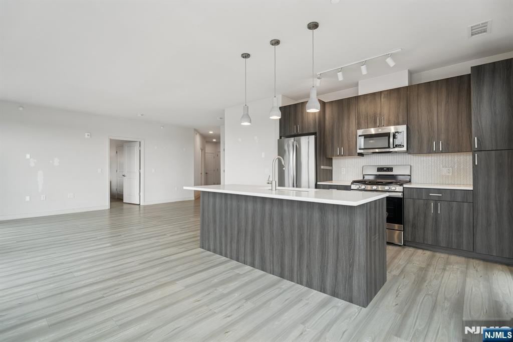 300 Market Street, Unit 422 Montvale, NJ 07645 - Photo 4 of 26 a kitchen with stainless steel appliances granite countertop a sink a stove and a wooden floors