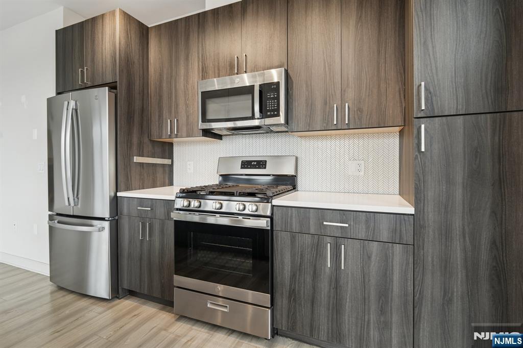 300 Market Street, Unit 422 Montvale, NJ 07645 - Photo 5 of 26 a kitchen with appliances a refrigerator and a stove top oven
