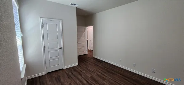 an empty room with wooden floor and closet