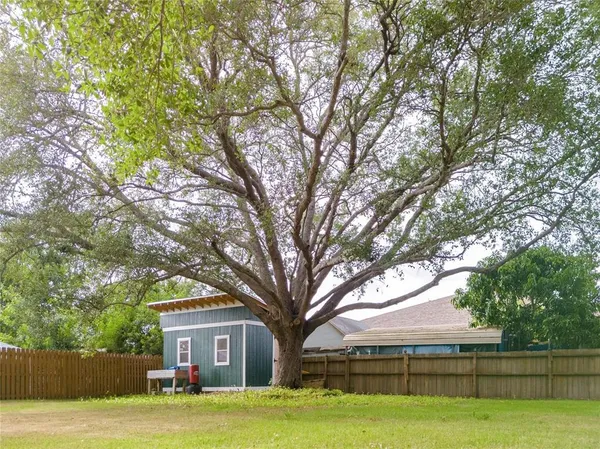 a front view of a house with garden and trees