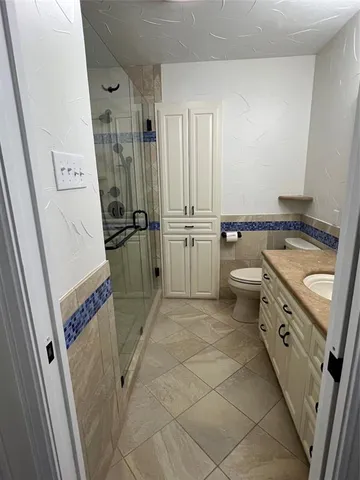 a bathroom with a granite countertop sink toilet and shower
