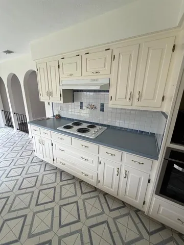 a kitchen with granite countertop white cabinets and sink