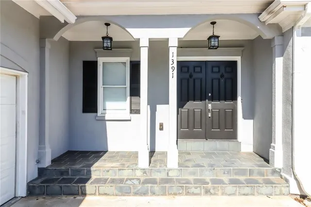 a view of an empty room with wooden floor fireplace and a window