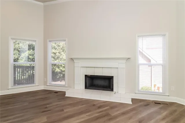 a view of a livingroom with wooden floor a ceiling fan and windows