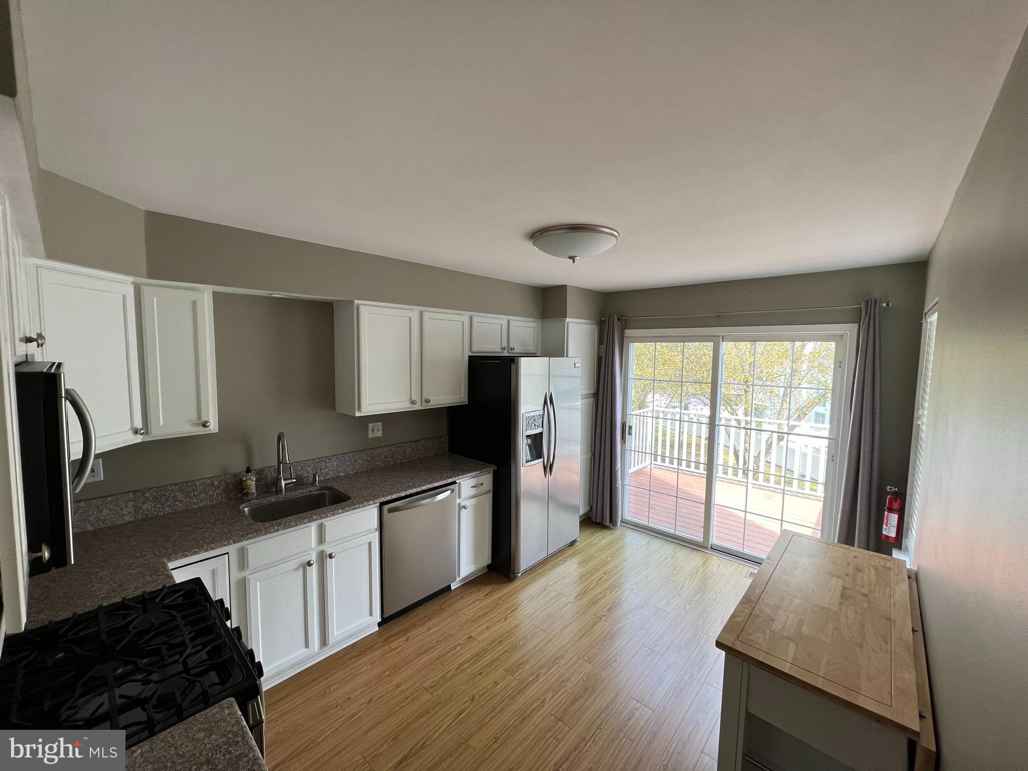 10 Howe Court Pennington, NJ 08534 - Photo 9 of 39 a kitchen with granite countertop a stove a sink a refrigerator and wooden cabinets